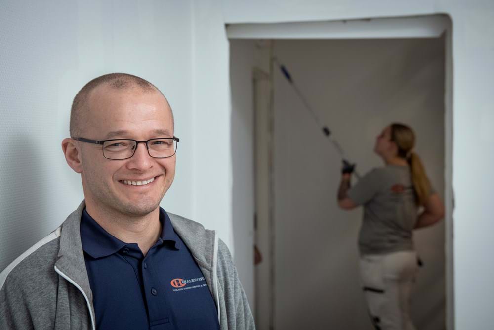 En sidegevinst ved at være en social ansvarlig virksomhed er, at medarbejderne ved, at hvis de selv får en skade, så bliver de ikke smidt ud af virksomheden. Det giver tryghed i organisationen, siger Michael Holm Hansen. I baggrunden malersvend Freja Holst. Foto Søren Hytting