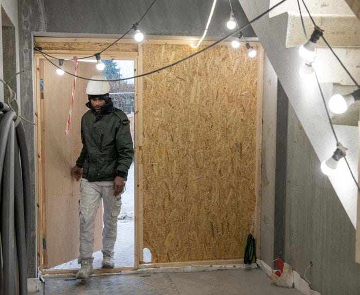 Dørpartierne til opgangene såvel som til lejlighederne holdes lukket med midlertidigt opsatte døre, så varmen holdes inde i byggeriet. Det er et af kravene til håndværkerne fra byggeledelsen. Foto Søren Hytting.