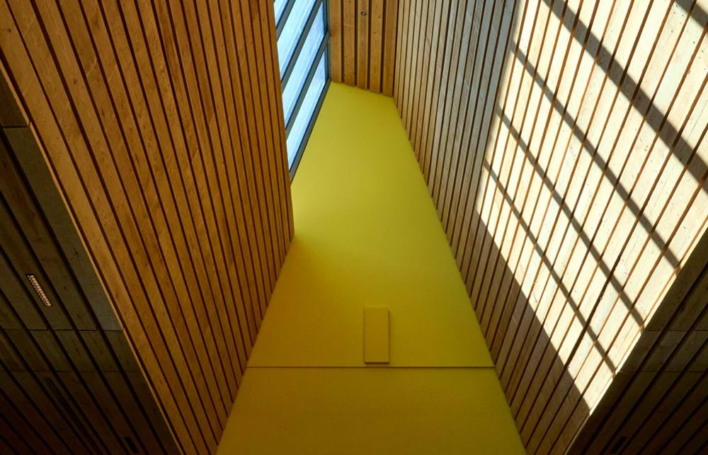 Billedkunstner Malene Bach har brugt et kunstnerisk greb. hvor en bærende betonbjælke gennem bygningen er fremhævet i gult. Foto Kirsten Bille.